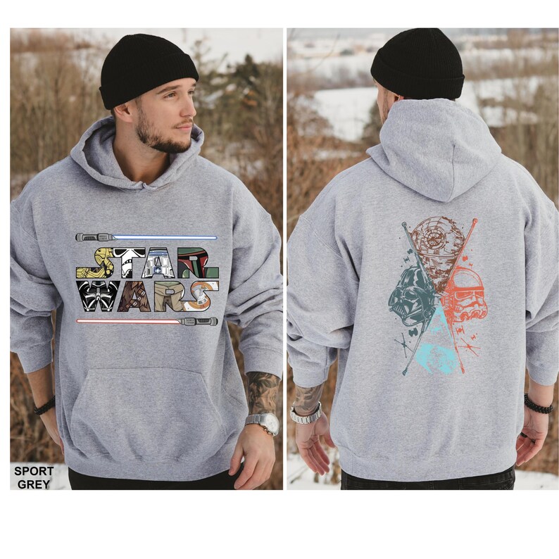 Puede incluir: Una sudadera con capucha gris claro de Star Wars con un gr&aacute;fico frontal con el logotipo de Star Wars y sables de luz. La parte posterior de la sudadera con capucha muestra un gr&aacute;fico de Darth Vader, un Stormtrooper y la Estrella de la Muerte. El texto "SPORT GREY" est&aacute; en la parte inferior izquierda.