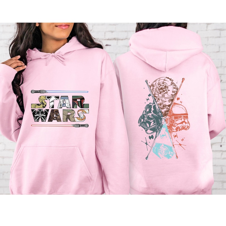 Puede incluir: Sudadera con capucha rosa claro con el logotipo de Star Wars en la parte delantera y un gr&aacute;fico en la parte trasera. El dise&ntilde;o frontal incluye el texto Star Wars con sables de luz. El gr&aacute;fico trasero presenta a Darth Vader, un Stormtrooper y la Estrella de la Muerte.