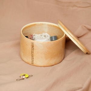 Puede incluir: Un letrero de madera rústica con el texto "Welcome to Our Home" en letras blancas. El letrero presenta un acabado envejecido y un diseño simple y acogedor, ideal para la decoración de la puerta principal.