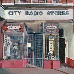 May include: A vintage storefront with a sign that reads "CITY RADIO STORES". The windows are covered with wire mesh and display the words "WIRELESS" and "COMPONENTS".