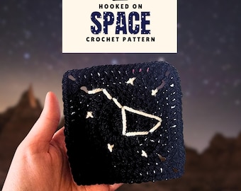 May include: A black crochet square with a white constellation design, held in a hand. The image includes a banner that reads "Hooked on Space Crochet Pattern" in blue and white text, with the Yarn Square logo.