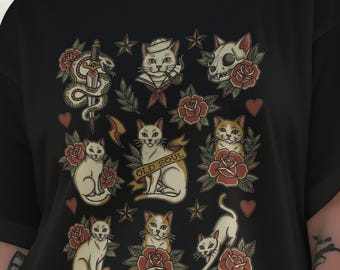 May include: A black t-shirt featuring a multi-colored graphic print of various cats, red roses, a snake wrapped around a dagger, a cat skull, and stars. A central banner across one cat reads "OLD SOUL" in black capital letters.
