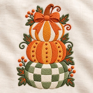 Op de afbeelding: Een borduurontwerp met een stapel van drie pompoenen. De bovenste pompoen is oranje en wit met een strik, de middelste is oranje met stippen en de onderste is groen en wit geblokt. Het geheel is versierd met groene bladeren en oranje bessen.