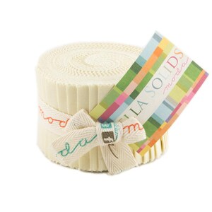 May include: A roll of cream-colored fabric strips, secured with a ribbon and bow. The ribbon has the word "moda" printed on it. A colorful tag with the words "Bella Solids" is attached to the fabric roll. The fabric is likely for quilting or sewing projects.