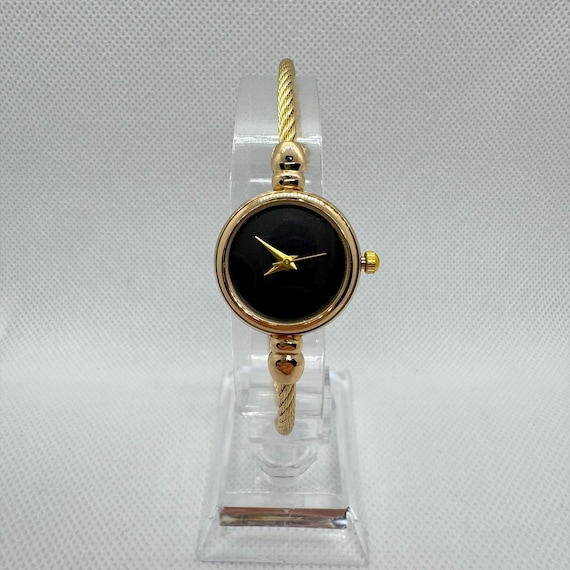 Montre bracelet femme dorée cadran noir minimaliste, montre vintage chic quartz, bijou élégant rétro, montre bracelet jonc sans chiffre