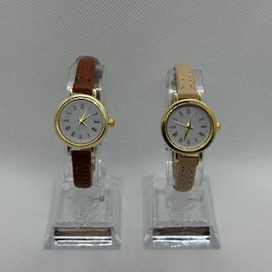 Vintage gold women’s watch, white Roman numeral dial, brown or beige leather strap, classic and elegant style