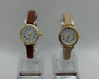 Vintage gold women’s watch, white Roman numeral dial, brown or beige leather strap, classic and elegant style