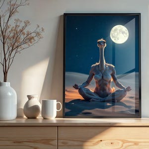Puede incluir: Impresión artística enmarcada que representa un avestruz meditando en un paisaje desértico bajo la luna llena. La obra de arte se exhibe en un mueble de madera, junto con jarrones blancos y una taza. La imagen tiene un tema surrealista y caprichoso.