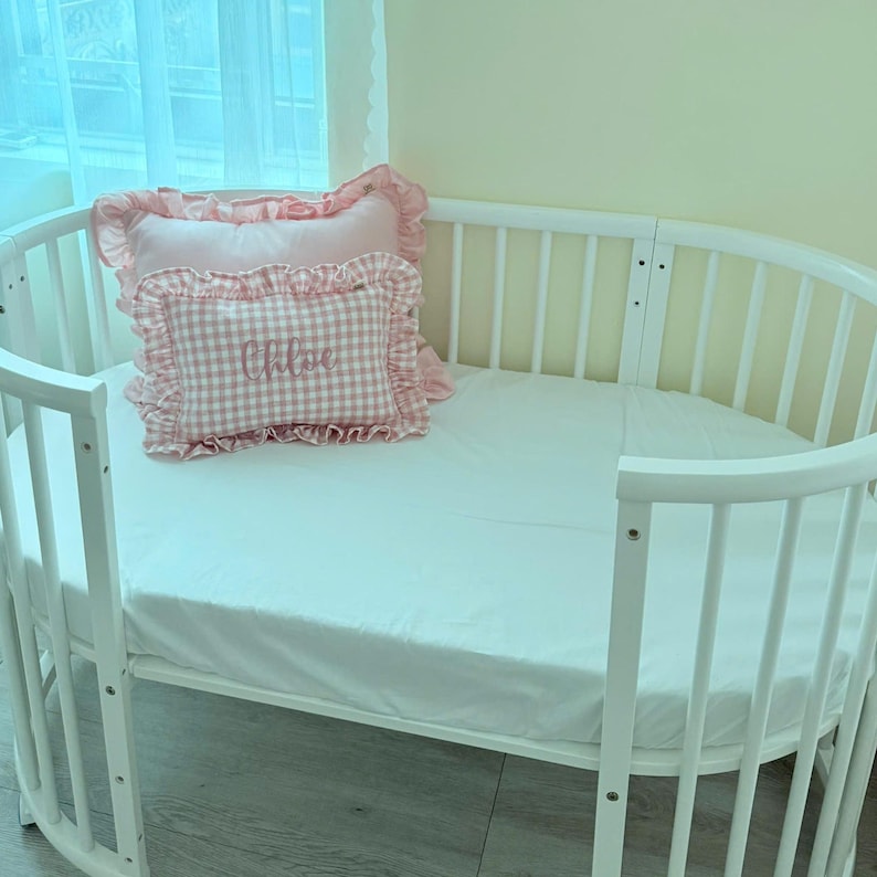 Ruffle baby pillow styled in crib as nursery décor