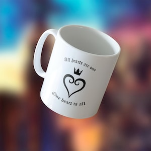 May include: White ceramic mug with a black heart design and the text "All hearts are one, One heart is all". The heart has a crown on top.