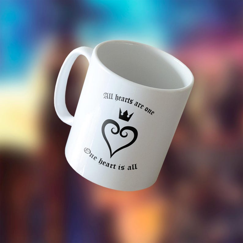 May include: White ceramic mug with a black heart design and the text "All hearts are one, One heart is all". The heart has a crown on top.