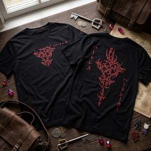 Peut inclure: Deux t-shirts noirs à manches courtes avec des motifs graphiques rouges. L'un présente un petit emblème rouge avec du texte japonais, tandis que l'autre arbore un grand motif tribal rouge complexe disposé verticalement avec des caractères japonais.
