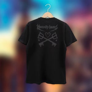 May include: Black t-shirt with a graphic print of the Kingdom Hearts logo and keyblades.