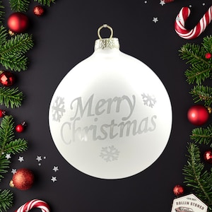 Hand Blown Glass Christmas Ornament with a merry christmas and snowflakes inspired picture on it.