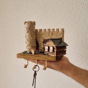 A small wall key holder made of wood using selfhardening mass. Decorated with artificial moss. An ideal gift and decoration for the hallway.