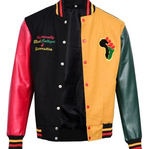 May include: A black, red, and green varsity jacket with a yellow panel on the right side. The jacket has a raised, embroidered fist in the shape of Africa on the yellow panel. The left side of the jacket has the text "Historically Black Colleges & Universities" embroidered in colorful thread.