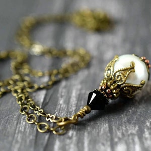 Victorian Pearl Necklace with Black Crystal - White Pearl Pendant On Antique Gold Chain - Tuxedo Wedding

Handmade Jewelry by MsBsDesigns.Etsy.com