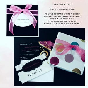 May include: A gift box wrapped in white paper with multicolored polka dots and a pink organza ribbon. Includes a black business card with gold swirls, a white thank you card, and a black gift box with a pink ribbon and a white oval label.