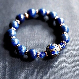 A blue stretch bracelet custom made to order with lapis blue gemstones and vintage style antique gold brass beads and bead caps.
