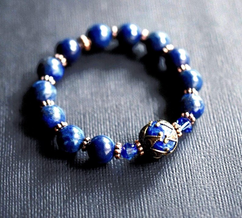 A blue stretch bracelet custom made to order with lapis blue gemstones and vintage style antique gold brass beads and bead caps.