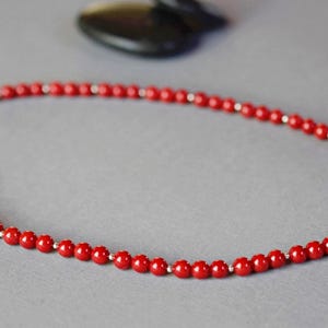 May include: A red coral bead necklace with a silver clasp.