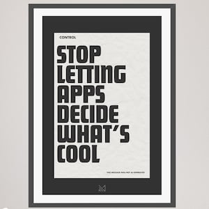 May include: A black and white poster with the text "STOP LETTING APPS DECIDE WHAT'S COOL" in bold, sans-serif font. The poster is framed in a black frame and is hanging on a white wall.