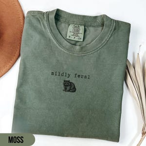 Pode incluir: Um conjunto de três canecas de cerâmica com acabamento fosco e salpicado. As canecas são em tons de creme, cinza claro e cinza escuro. Cada caneca tem um design simples e minimalista.
