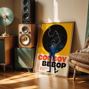 Puede incluir: Una habitación con equipo de audio de estilo vintage y un póster enmarcado de "Cowboy Bebop". Los altavoces están apilados en un mueble verde. Un sillón de cuero marrón con una manta está al lado del póster. El póster tiene un fondo amarillo y las palabras "Cowboy Bebop".