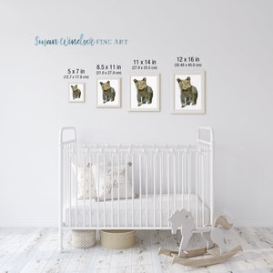 May include: Four framed prints of a watercolor painting of a brown bear cub. The prints are displayed on a white wall above a white crib. The prints are available in four sizes: 5x7 inches, 8.5x11 inches, 11x14 inches, and 12x16 inches.