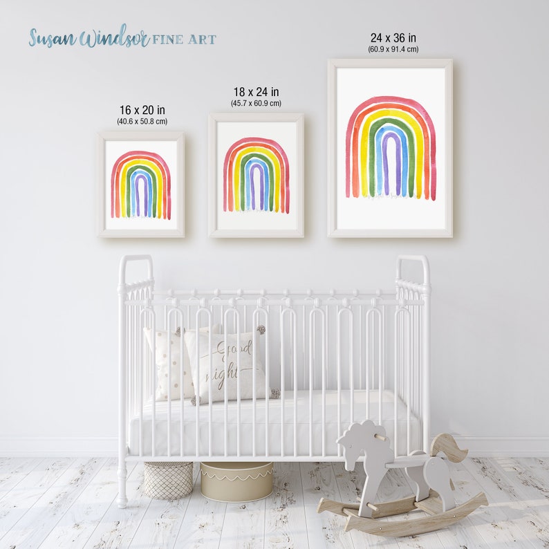 May include: Three framed watercolor rainbow prints in different sizes, 16 x 20 inches, 18 x 24 inches, and 24 x 36 inches. The prints are hanging on a white wall above a white crib.