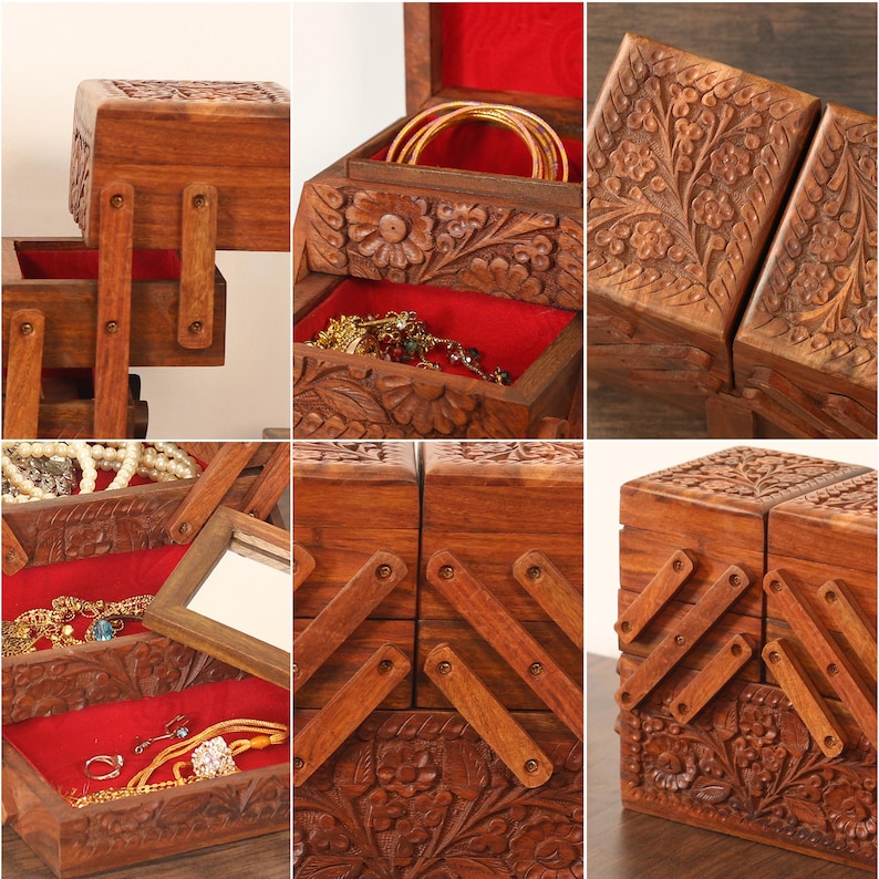 May include: A wooden jewelry box with a rich brown finish, featuring intricate floral carvings. The box opens to reveal multiple compartments lined with red velvet. The design includes a mirror and various storage levels for jewelry.