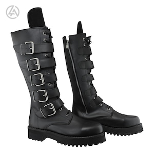 May include: Black knee-high boots with multiple buckle straps and a thick sole. One boot has a side zip. The boots have a lace-up design at the ankle and are made of a smooth, matte material.