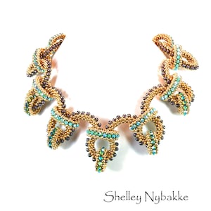 May include: A gold and purple beaded necklace with a unique, twisted design. The necklace features a series of loops and swirls, creating a dramatic and eye-catching look.  The beads are iridescent, adding to the overall sparkle and shine of the piece.