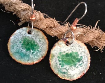 May include: A pair of green and white oval ceramic earrings with copper accents and silver hooks.