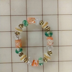 Ivory Color & Ice with with Orange, Green Lampwork Beads and Gold Fluted Beads.