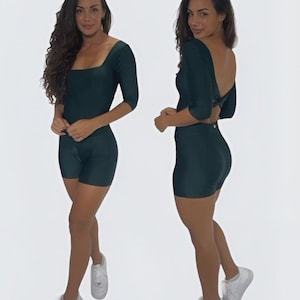 Puede incluir: Dos vistas de un body verde oscuro con cuello cuadrado y mangas tres cuartos. La parte inferior tipo short se combina con zapatillas blancas. La modelo está de pie frente a un fondo blanco.