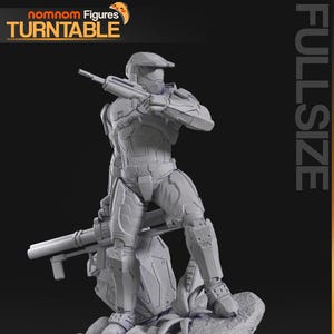 Puede incluir: Figura de acción gris de tamaño completo de un soldado futurista sosteniendo un rifle, de pie sobre una base rocosa con follaje. La figura lleva una armadura detallada. La esquina superior izquierda tiene el texto "nomnom Figures TURNTABLE".