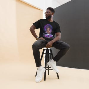 Peut inclure: T-shirt noir avec un graphisme de visage féminin aux accents violets et bleus, et le texte "DISCONNECTED, STILL ALIVE". La personne sur l'image porte un jean noir et des baskets blanches.