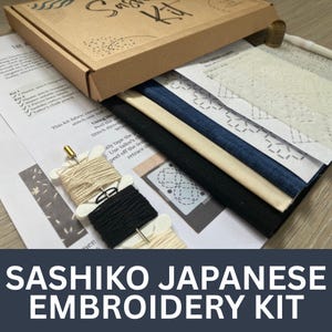 May include: A Sashiko Japanese embroidery kit in a brown cardboard box. The kit includes fabric, thread spools, a thimble, and a plastic stitch template. The text "Sashiko Japanese Embroidery Kit" is displayed in white at the bottom of the image.