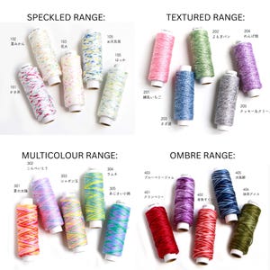 May include: A collection of sewing thread spools organised into four categories: Speckled Range, Textured Range, Multicolour Range, and Ombre Range. Each spool is labelled with a numerical code and Japanese text, showcasing various colour patterns and textures.