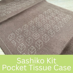 Peut inclure: Un étui à mouchoirs de poche marron avec un motif de feuilles blanches. Le tissu est plié, montrant la texture et le design. Le texte "Sashiko Kit Pocket Tissue Case" est en bas.