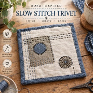 May include: A square fabric trivet featuring a beige base with a dark blue denim border. The centre displays a rectangular olive patch and two circular stitched motifs in dark blue and black thread, accented by straight and dashed running stitch lines.