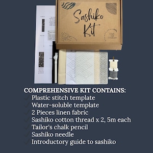 May include: A Sashiko Kit in a brown box with the text "Sashiko Kit". The kit includes linen fabric, thread, a needle, a chalk pencil, and a guide. The kit also includes a plastic stitch template and a water-soluble template.
