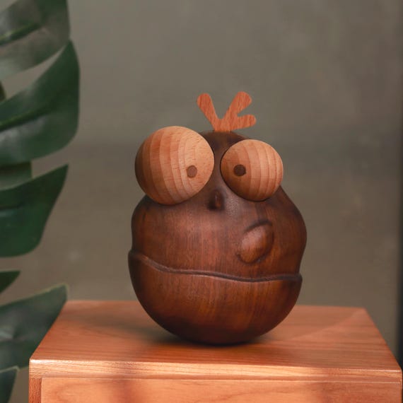 A hand-turned wooden chicken with an egg-shaped body carved from contrasting walnut and beech — the kind of whimsical desk object that sparks a conversation every single time.