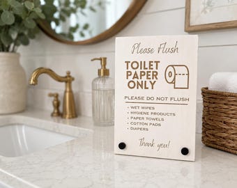 May include: A rectangular light-coloured wooden sign with dark brown text that reads: Please Flush TOILET PAPER ONLY. PLEASE DO NOT FLUSH: WET WIPES, HYGIENE PRODUCTS, PAPER TOWELS, COTTON PADS, DIAPERS. Thank you! The sign features two small black circular accents.