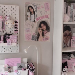 Peut inclure: Une affiche murale rectangulaire présentant deux photographies d'une personne nommée Wonhee du groupe ILLIT. L'affiche comprend du texte rose de style manuscrit, des gribouillis de cœurs et un lapin, ainsi que le texte Wonhee, ILLIT et The cutest girl in the world.