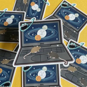 May include: A collection of stickers featuring a laptop design with a space-themed screen. The screen displays planets, stars, and a moon with a face. A cartoon mouse is on the keyboard. The stickers have a white border and the word "Mouz".