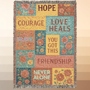 以下が含まれることがあります： パッチワークデザインの織りスローケット。ブランケットには、花柄と「希望」、「勇気」、「友情」などのインスピレーションを与える言葉が描かれています。カラーパレットは、黄色、ティール、コーラルの色合いで、フリンジエッジが付いています。