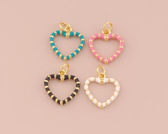 May include: Four gold heart-shaped charms with different colored enamel stripes. The charms are turquoise, pink, black, and white.