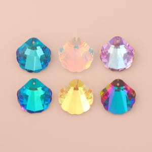 Puede incluir: Seis colgantes de cristal iridiscente en forma de concha marina en tonos azul, rosa, amarillo y arcoíris. Cada colgante tiene un diseño facetado y un pequeño agujero en la parte superior para ensartar.